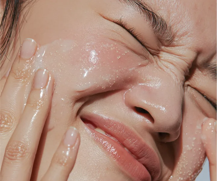 Close-up of a smiling face with a translucent product on the cheek